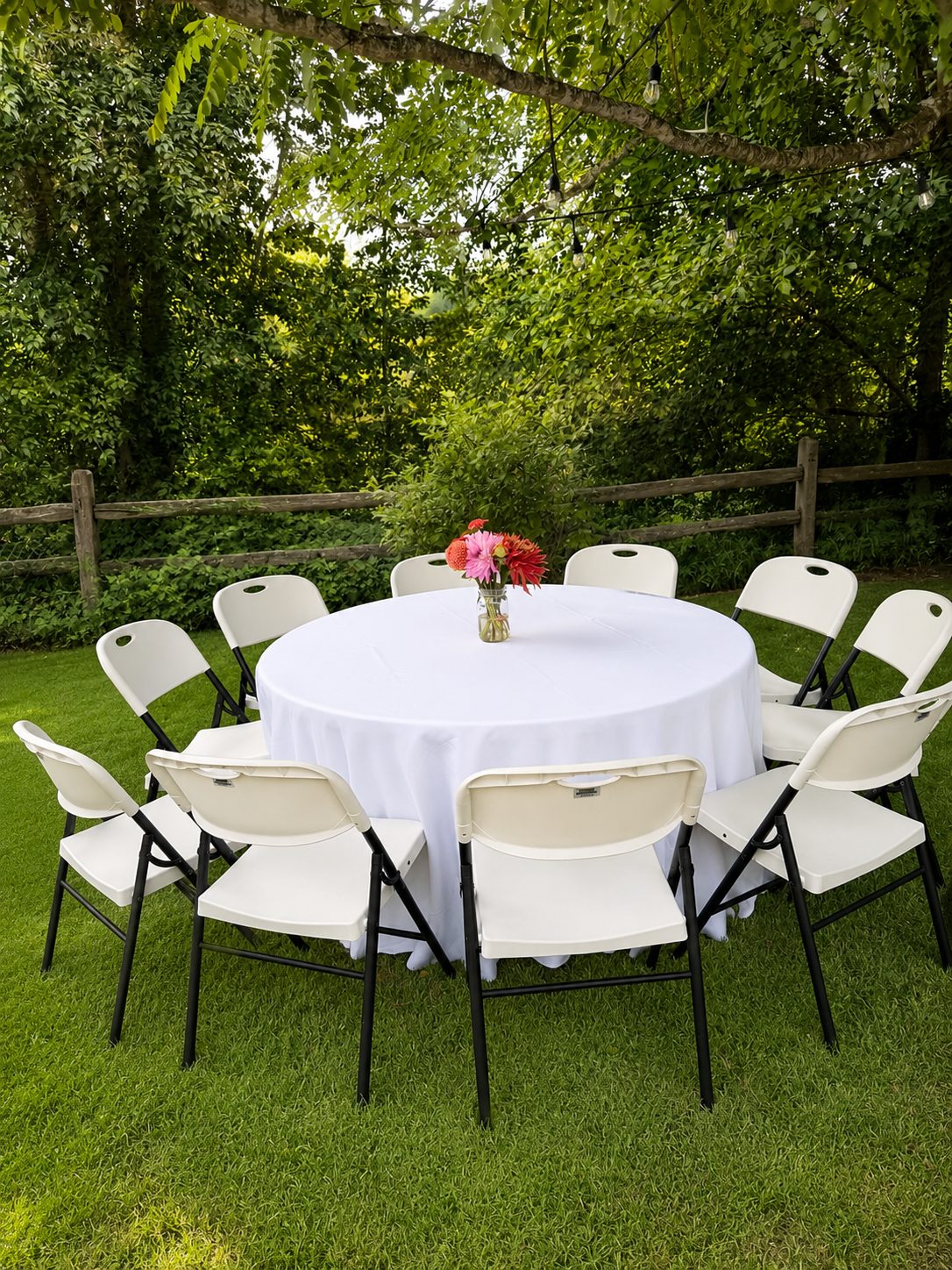 Round table and white chairs set up in a backyard under string lights — a real Mateo Party Co. setup.
