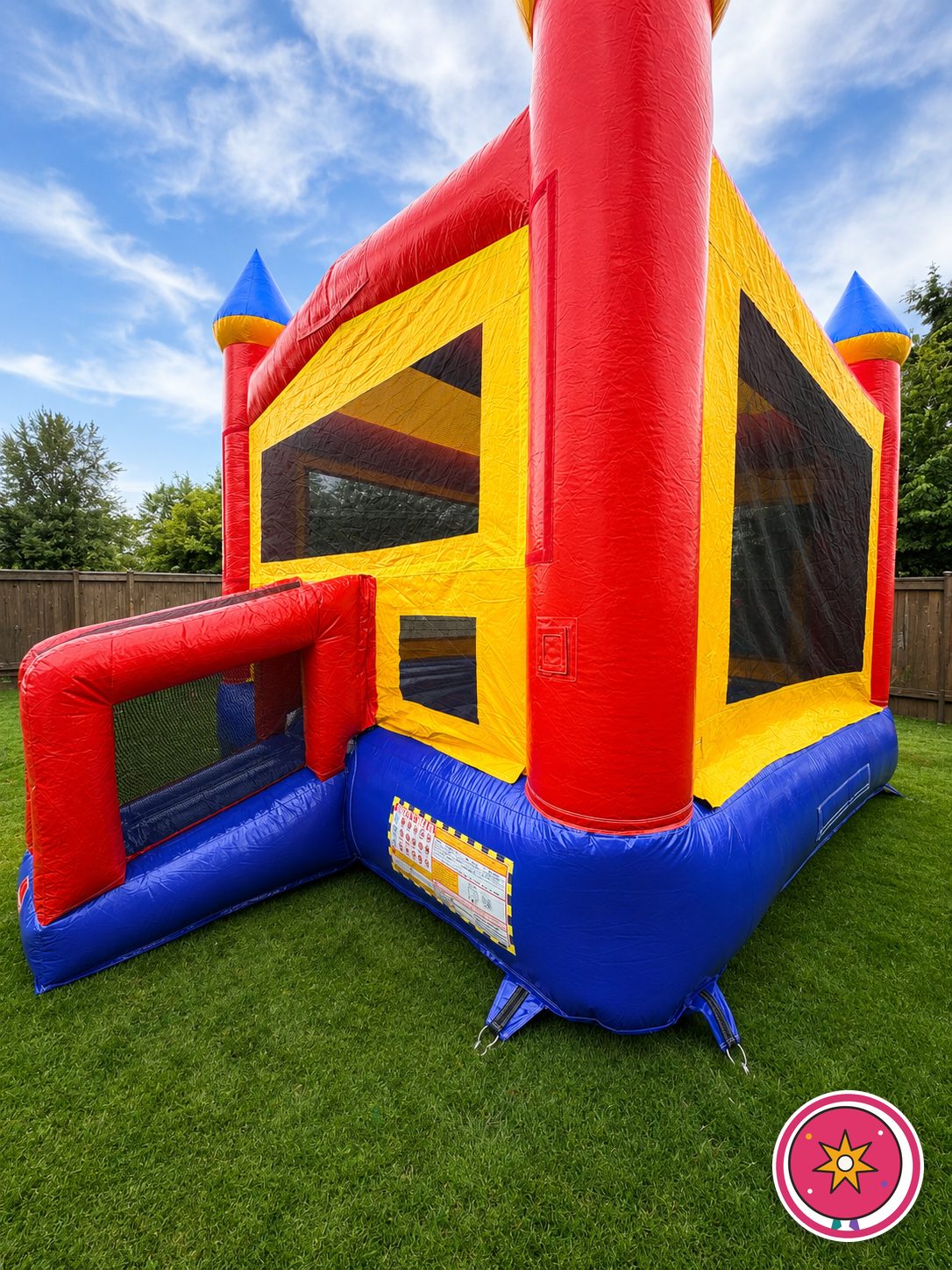 Close-up of the Mateo Party Co. red, yellow and blue castle bounce house with basketball hoop